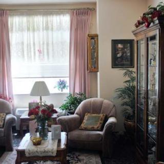 A cozy living room with soft chairs, a coffee table, and decorative elements.