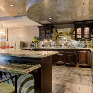 A luxurious modern kitchen with marble countertops and a stylish bar area.