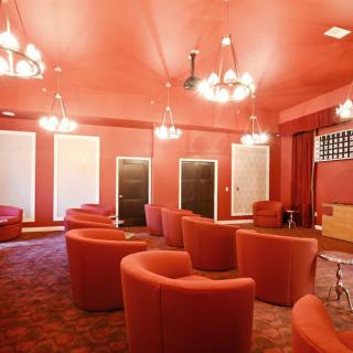 A red-themed lounge with comfortable seating and elegant chandeliers.