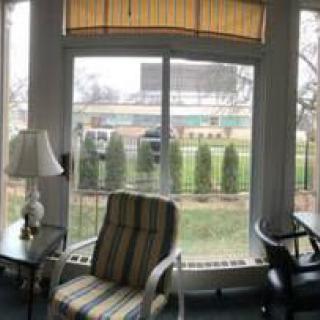 A cozy room with a large window overlooking a garden.
