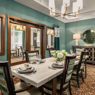 An elegant dining room with a sophisticated table setting and warm lighting.