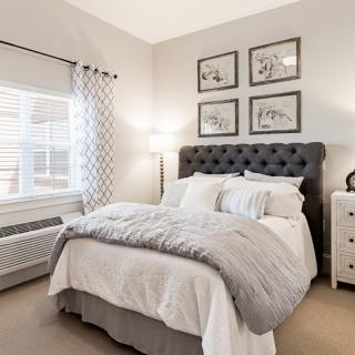 A cozy and elegantly decorated bedroom with neutral tones and modern furnishings.