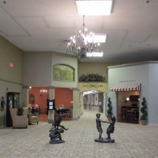 A spacious lobby area with sculptures, elegant chandeliers, and cozy seating arrangements.