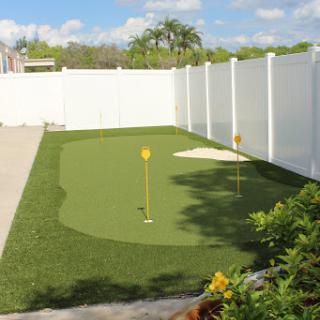 A well-maintained backyard putting green, perfect for golf enthusiasts to practice their skills.
