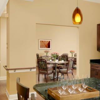 A cozy dining area visible through an archway, showcasing modern furniture and warm lighting.