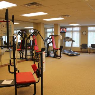A view of a well-equipped gym featuring exercise machines and a treadmill, designed for fitness enthusiasts.