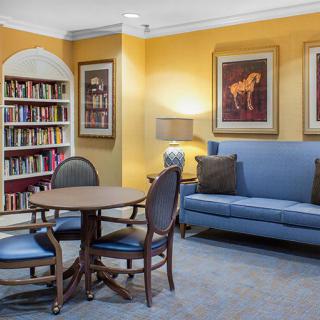 Cozy library corner with bookshelves, seating, and decorative artwork.