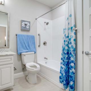 A clean and modern bathroom with a blue-themed shower curtain and towel.