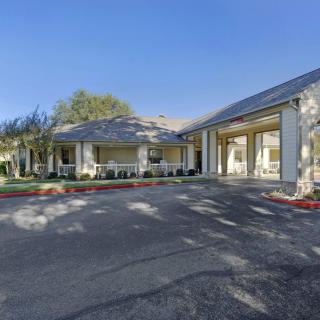 A residential building with a driveway on a sunny day.
