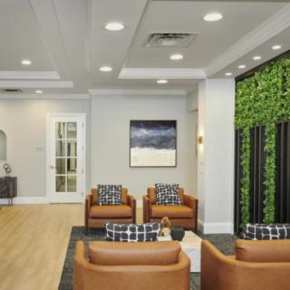 A modern lobby with comfortable seating and a green accent wall.