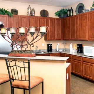 A warm and inviting kitchen with wooden cabinets, a countertop, various appliances, and decorative elements.