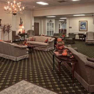 A cozy living room with elegant sofas, a chandelier, and seasonal decor.