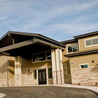 A modern residential building featuring a unique architectural design with stone and stucco elements.