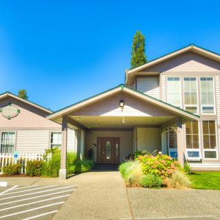 A suburban residential building with a welcoming entrance and well-maintained front yard.