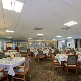 A spacious dining area with neatly arranged tables and chairs, ready for guests.