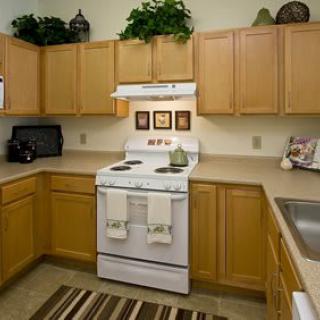A modern kitchen with wooden cabinets and a white stove.