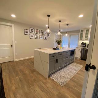 A modern kitchen interior featuring a central island and pendant lighting.