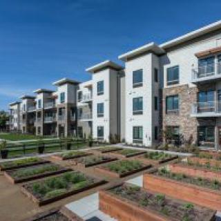 Modern apartment buildings with landscaped outdoor areas.