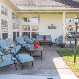 A cozy outdoor patio area featuring blue cushioned furniture and potted plants.