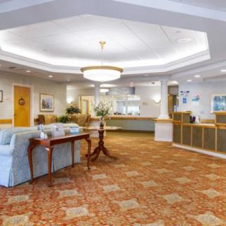 A spacious and well-lit lobby area featuring a reception desk and comfortable seating.
