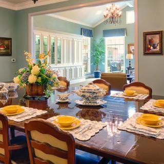 An elegantly decorated dining room with a beautifully set table and natural lighting.
