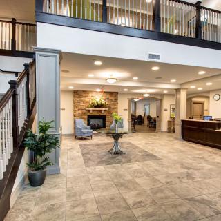 A modern and inviting lobby with a reception desk, seating area, and staircase.