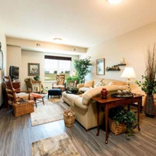 A cozy living room with a blend of modern and traditional decor, featuring comfortable seating, lush plants, and warm lighting.