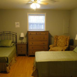 A cozy bedroom with twin beds and wooden furniture.