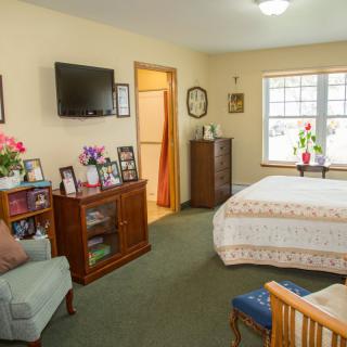 Cozy bedroom with a bed, television, and furniture.