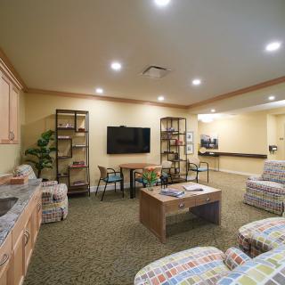A cozy living room with armchairs, a coffee table, and a television.