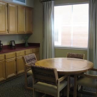 A cozy dining area with a round table, chairs, and large window.