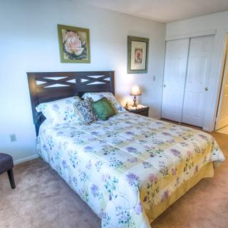 A cozy bedroom with floral bedding and minimalist decor.