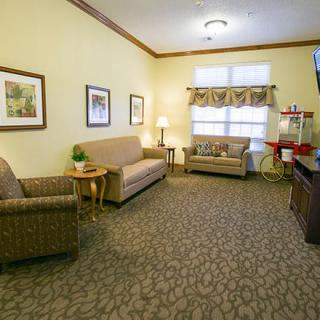 A cozy living room with two sofas, patterned carpet, and a television.