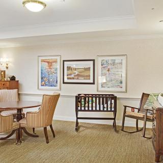 A cozy living area featuring a table with chairs, wall art, and additional seating options.