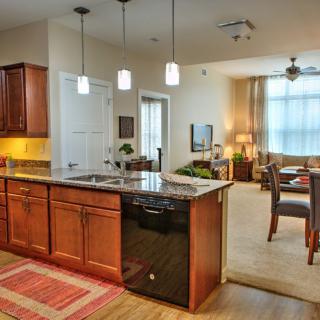 A modern open-concept kitchen and dining area with pendant lighting and an island counter.