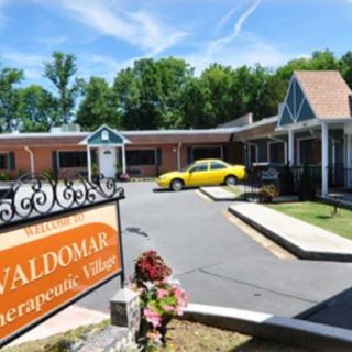 A roadside motel with a parking lot and a yellow car parked outside.