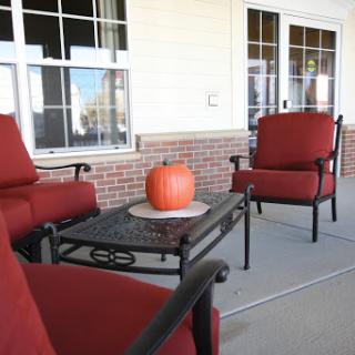 A cozy outdoor seating area adorned with a pumpkin, perfect for autumn gatherings.