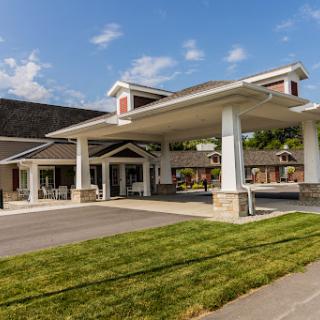 A welcoming hotel entrance with a well-maintained lawn and clear blue skies.