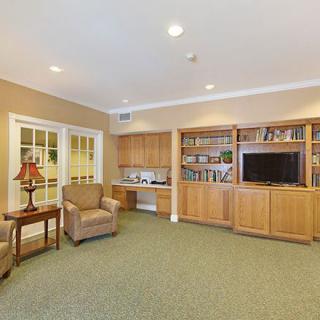 A cozy living room with a bookshelf, television, and comfortable seating.