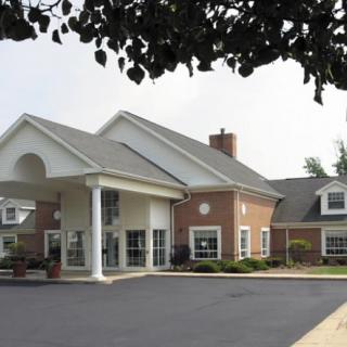 A suburban residential building with a large driveway and classic architectural design.