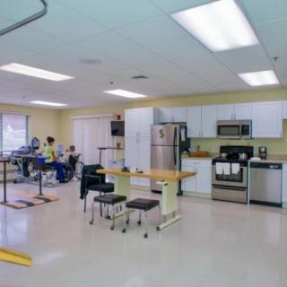 A rehabilitation center room featuring kitchen facilities and therapy equipment.