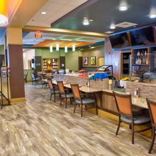 A modern restaurant interior with a bar and ample seating.
