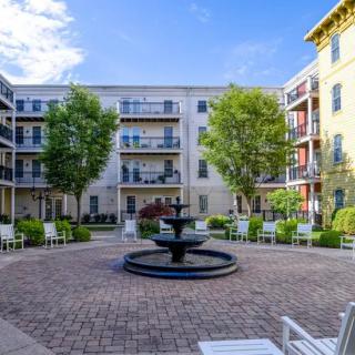 A peaceful courtyard with a central fountain surrounded by apartment buildings and greenery.