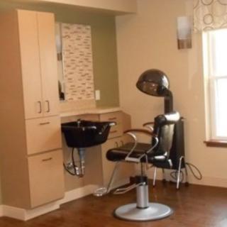 A cozy hair salon setup featuring a salon chair and hair dryer.