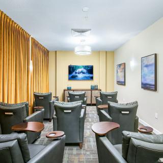 A cozy home theater room with comfortable seating and a large TV screen.