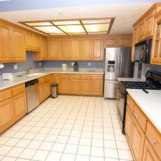 Modern kitchen with wood cabinets and stainless steel appliances.