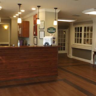 A neatly designed reception area featuring a wooden counter and modern lighting.