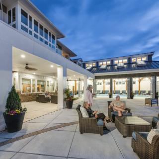A modern residential patio with outdoor seating and people enjoying an evening gathering.
