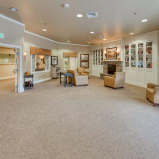 A spacious and well-lit lobby area with comfortable seating and carpeted flooring.