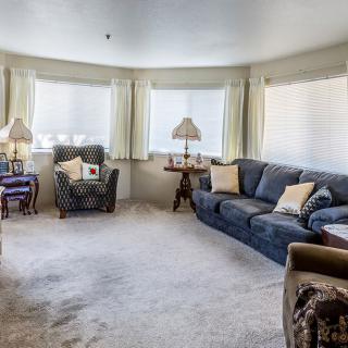 A cozy living room with comfortable furniture and ample natural light.